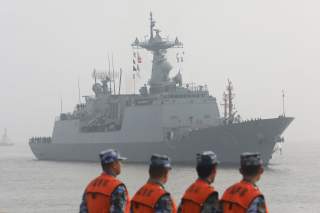 Chinese People's Liberation Army (PLA) Navy officials stand guard as a South Korean naval ship approaches the dock in Shanghai, China January 14, 2019. REUTERS/Stringer ATTENTION EDITORS - THIS IMAGE WAS PROVIDED BY A THIRD PARTY. CHINA OUT.