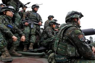 Soldiers sit on an M60A3 tank for a group photograph after an anti-invasion drill to test readiness ahead of Lunar New Year, simulating enemy invasion and the safeguarding of the weapon systems in case of air raid, in Taichung, Taiwan January 17, 2019. RE