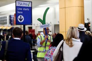 A man guides passengers towards a Transportation Security Administration (TSA) PreCheck security checkpoint at Hartsfield-Jackson Atlanta International Airport amid the partial federal government shutdown, in Atlanta, Georgia, U.S., January 18, 2019.