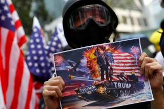 A protester holds up a sign featuring U.S. President Donald Trump in Central, Hong Kong, China September 8, 2019. REUTERS/Kai Pfaffenbach NO RESALES. NO ARCHIVES.