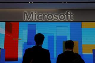 FILE PHOTO: Visitors stand in front of a display screen at Microsoft's new Oxford Circus store ahead of its opening in London, Britain July 9, 2019. REUTERS/Simon Dawson/File Photo