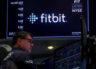 A trader works at his post as the logo for wearable device maker Fitbit Inc. is displayed on a screen on the floor of the New York Stock Exchange (NYSE) as begins public trading in New York, U.S., October 28, 2019. REUTERS/Brendan McDermid