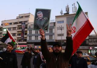 A man holds a picture of late Iranian Major-General Qassem Soleimani, as people celebrate in the street after Iran launched missiles at U.S.-led forces in Iraq, in Tehran, Iran January 8, 2020. Nazanin Tabatabaee/WANA (West Asia News Agency) via REUTERS