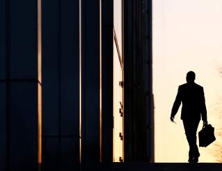 A worker arrives at his office in the Canary Wharf business district in London, Britain February 26, 2014. To match Special Report CHINA-INVESTMENT/EUROFX REUTERS/Eddie Keogh/File Photo