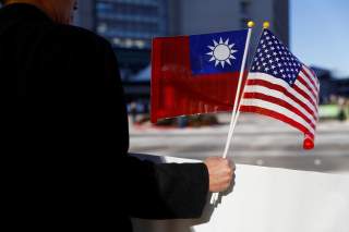 A demonstrator holds flags of Taiwan and the United States in support of Taiwanese President Tsai Ing-wen during an stop-over after her visit to Latin America in Burlingame, California, U.S., January 14, 2017. REUTERS/Stephen Lam