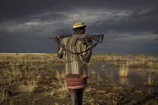 An armed Turkana man walks towards the shores of Lake Turkana near a temporary fishing camp some kilometres from Todonyang near the Kenya-Ethiopia border in northwestern Kenya October 12, 2013. The Turkana are traditionally nomadic pastoralists, but they 