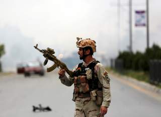 A member of Afghan security forces holds a rifle at the site of an attack near the Afghan parliament in Kabul, Afghanistan June 22, 2015. A Taliban suicide bomber and six gunmen attacked the Afghan parliament on Monday, wounding at least nineteen people a