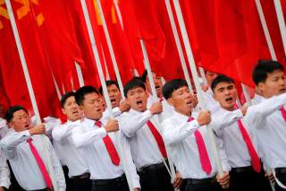 Students carrying party flags shout slogans as they march past North Korean leader Kim Jong Un during a mass rally and parade in the capital's main ceremonial square, a day after the ruling party wrapped up its first congress in 36 years by elevating him 