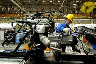 An employee works on an assembly line producing automobiles at a factory in Qingdao, Shandong Province, China, March 1, 2016. REUTERS/Stringer/File Photo