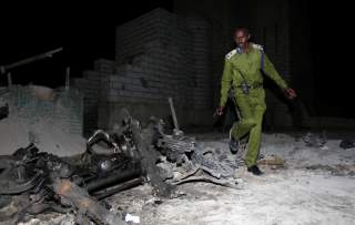 A Somali policeman inspects the scene of a suicide car explosion near the parliament in the capital Mogadishu, November 5, 2016. REUTERS/Feisal Oma