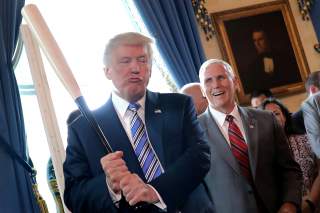 Vice President Mike Pence laughs as U.S. President Donald Trump holds a baseball bat as they attend a Made in America product showcase event at the White House in Washington, U.S., July 17, 2017. REUTERS/Carlos Barria TPX IMAGES OF THE DAY