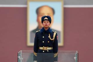 A member of Chinese People's Liberation Army (PLA) stands guard in front of a portrait of late Chinese Chairman Mao Zedong at the Tiananmen in Beijing, China March 4, 2018.