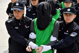 Chinese police officers escort Taiwanese nationals who were arrested in the Philippines on suspicion of telecoms fraud, at an airport in Tianjin, China April 4, 2018. REUTERS/Stringer