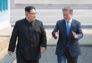 South Korean President Moon Jae-in walks with North Korean leader Kim Jong Un during their meeting at the truce village of Panmunjom inside the demilitarized zone separating the two Koreas, South Korea, April 27, 2018. Korea Summit Press Pool/Pool via Reu
