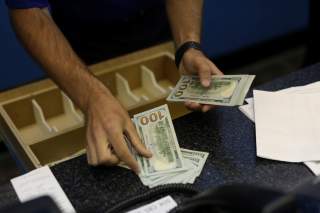 A teller is counting money before betting opens to the public at Monmouth Park Sports Book by William Hill, ahead of the opening of the first day of legal betting on sports in Oceanport, New Jersey, U.S., June 14, 2018. REUTERS/Mike Segar