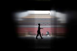 A security guard walks at the Gate of Supreme Harmony, in a part where it is closed for a major renovation work, at the Forbidden City in central Beijing, China July 31, 2018. REUTERS/Jason Lee