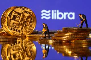 Small toy figures are seen on representations of virtual currency in front of the Libra logo in this illustration picture, June 21, 2019. REUTERS/Dado Ruvic