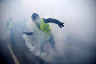 FILE PHOTO: Tear gas fills the air as a protester wearing a yellow vest, a symbol of a French drivers' protest against higher diesel taxes, demonstrates near the Place de l'Etoile in Paris, France, December 1, 2018. REUTERS/Stephane Mahe/File Photo