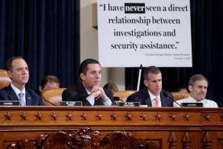 A sign sits behind House Intelligence Chairman Adam Schiff, ranking member Devin Nunes, Republican counsel Steve Castor and Rep. Jim Jordan (R-OH) during a House Intelligence Committee hearing featuring witness Marie Yovanovitch, former U.S. ambassador