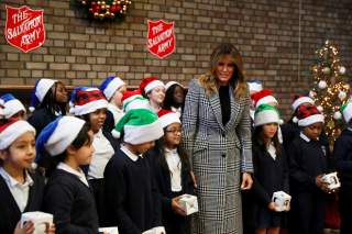 U.S. first lady Melania Trump poses with a children choir after joining local school students and U.S. Marines stationed at the U.S. Embassy, wrapping holiday presents to be donated to the Salvation Army, at the Salvation Army Clapton Center