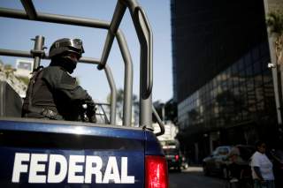 A federal police officer keeps watch after the U.S. Attorney General William Barr's convoy arrived at the Mexico's Attorney General Office (FGR) ahead of his meeting with the Mexican Attorney General Alejandro Gertz Manero, in Mexico City, Mexico