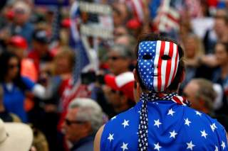 A pro-Trump rally participant wears a U.S. flag during the Southern California Make America Great Again march in support of President Trump, the military and first responders at Bolsa Chica State Beach in Huntington Beach, California, U.S. March 25, 2017.