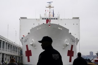 An NYPD officer is pictured as the USNS Comfort is pulled into a berth in Manhattan during the outbreak of coronavirus disease (COVID-19), in the Manhattan borough of New York City, New York, U.S., March 30, 2020. REUTERS/Carlo Allegri