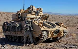 U.S. Army Soldier from the 3rd Armored Brigade Combat Team, 1st Infantry Division pulls security next to a M2 Bradley Infantry Fighting Vehicle during Decisive Action rotation 13-03 on Jan. 19, 2013 at the National Training Center in Fort Irwin, Calif. De