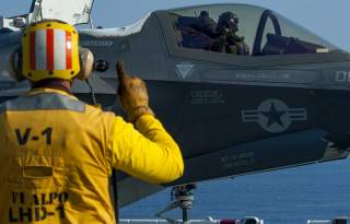 PACIFIC OCEAN (July 17, 2018) Aviation Boatswain's Mate (Handling) 2nd Class James Spencer signals the pilot of an F-35B Lightning II aircraft 