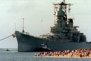 People gather on the beach to see the battleship USS Missouri (BB 63) enter the channel into Pearl Harbor, Hawaii, on June 22, 1998.