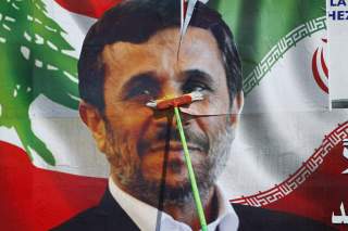 A worker puts up a billboard poster of Iranian President Mahmoud Ahmadinejad in Deir al-Zahrani village at southern Lebanon October 9, 2010. Ahmadinejad plans to visit Lebanon next Wednesday and he is expected to tour villages in southern Lebanon. REUTERS