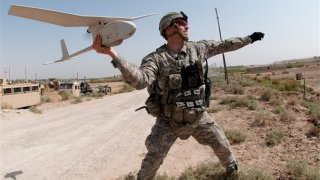 Army 1st Lt. Steven Rose launches an RQ-11 Raven unmanned aerial vehicle near a new highway bridge project along the Euphrates River north of Taqqadum, Iraq, Oct. 9, 2009. U.S. Army photo by Spc. Michael J. MacLeod  