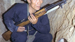 Viet Cong insurgent crouching in a bunker holding an SKS rifle. (U.S. Air Force photo).