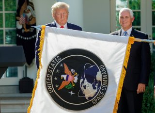 U.S. President Donald Trump stands behind a U.S. Space Command flag with Vice President Mike Pence at an event to officially launch the United States Space Command in the Rose Garden of the White House in Washington, U.S., August 29, 2019. REUTERS/Kevin L