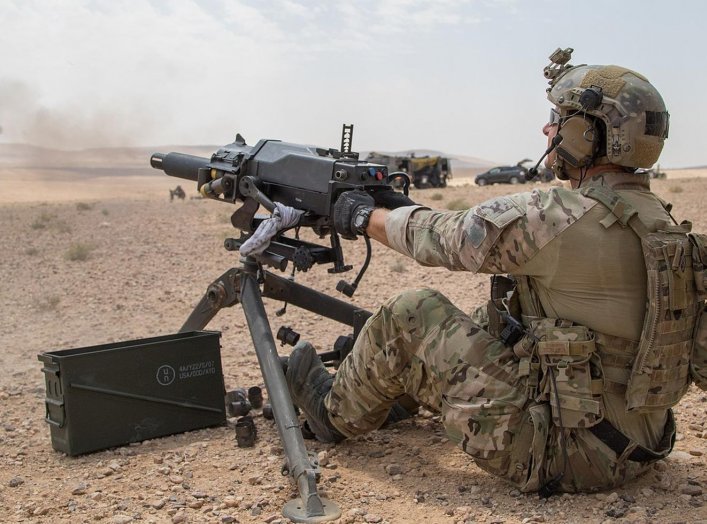 A soldier assigned to U.S. Army Special Operations Command demonstrates firing positions on the Mk 47 Strike 40mm grenade launcher to a member of the Saudi Arabian Naval Special Forces during joint forces weapons training in a tactical training area in Am