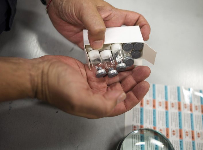 U.S. Customs and Border Protection officer Boris Sapozhnikov looks at counterfeit drugs seized by the agency at its offices at John F. Kennedy Airport in New York August 15, 2012. REUTERS/Keith Bedford