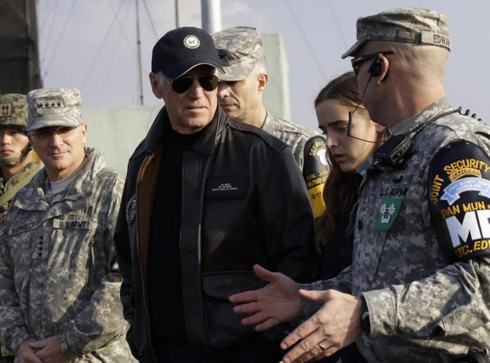 U.S. Vice President Joe Biden (C) is briefed by Lt. Col. Daniel Edwan (R), the commander of the Joint Security Area (JSA) Security Battalion at Observation Post Ouellette, during a tour of the Demilitarized Zone (DMZ), the military border separating the t