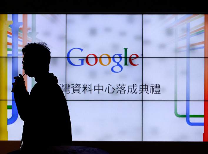 A man walks past a TV wall during a media tour at the Google data centre in Changhua Coastal Industrial Park, central Taiwan, December 11, 2013. REUTERS/Pichi Chuang
