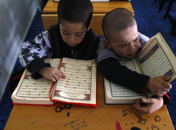 Uighur refugee boys read the Koran where they are housed in a gated complex in the central city of Kayseri, Turkey, February 11, 2015. REUTERS/Umit Bektas