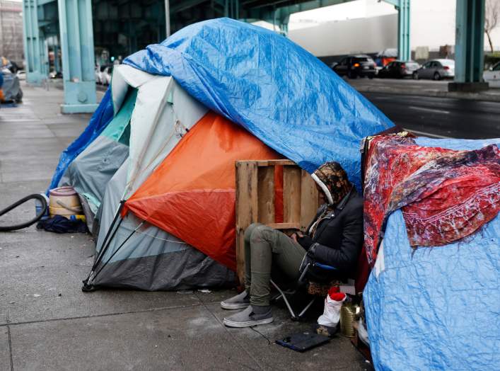 A homeless man, takes shelter under a freeway during an El Nino driven storm in San Francisco, California January 6, 2016. REUTERS/Beck Diefenbach