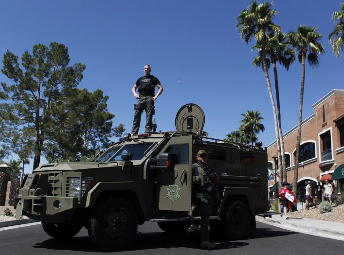 A Maricopa County, Arizona police SWAT team with an armored vehicle stand guard outside a campaign rally being held by Republican U.S. presidential candidate Donald Trump in Fountain Hills, Arizona March 19, 2016. REUTERS/Ricardo Arduengo