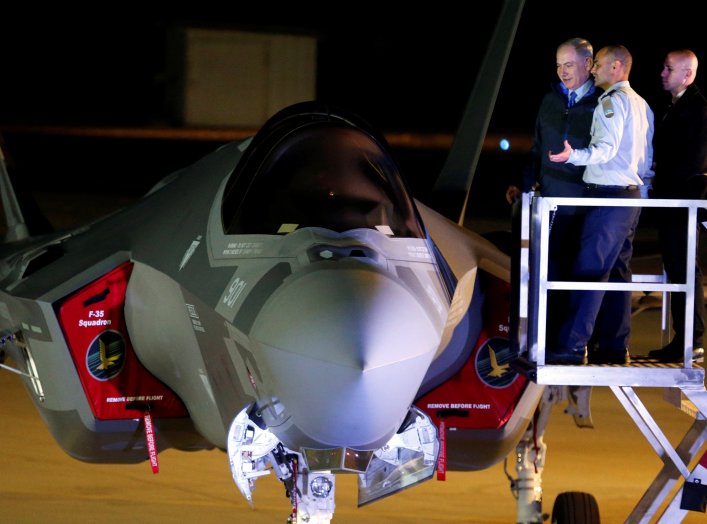 Israeli Prime Minister Benjamin Netanyahu stands next to a F-35 fighter jet just after it landed in Israel at Nevatim air base after the Israeli air force bought them at Nevatim