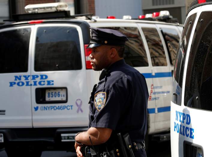 A New York City Police Department (NYPD) officer stands guard outside the 46th police precinct after a gunman fatally shot a female New York City police officer in an unprovoked attack early on Wednesday in the city's Bronx borough of New York City, U.S.,