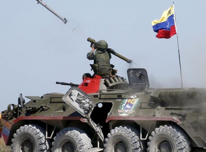 A serviceman from Venezuela fires an anti-aircraft missile with a Russian-made Igla ground-to-air launcher as he sits on top of an armoured personnel carrier (APC) during the Air defense battle masters competition as part of the International Army Games 2