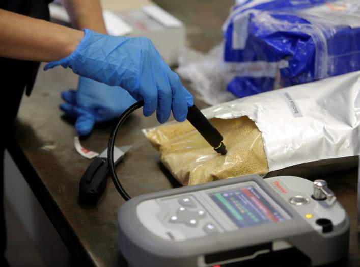 U.S. Customs and Border Protection officer Ella Olejnik uses an infrared machine to test a substance in a plastic bag at the International Mail Facility at O'Hare International Airport in Chicago, Illinois, U.S. November 29, 2017.
