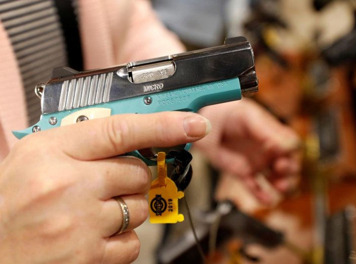 A woman looks over a semi-automatic handgun Kimber Micro Bel Air, a .380 ACP caliber, during the SHOT (Shooting, Hunting, Outdoor Trade) Show in Las Vegas, Nevada, U.S., January 22, 2019. Picture taken January 22, 2019. REUTERS/Steve Marcus