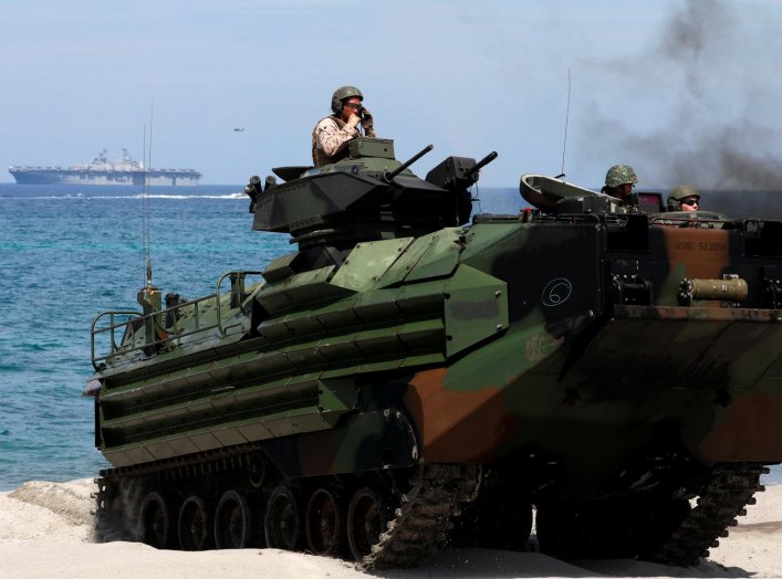 With the USS-Wasp in the background, U.S. Marines ride an amphibious assault vehicle during the amphibious landing exercises of the U.S.-Philippines war games promoting bilateral ties at a military camp in Zambales province, Philippines, April 11, 2019. R