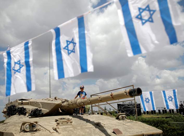 A boy stands atop an old tank during Memorial Day ceremony at Latrun's armoured corps memorial site, Israel May 8, 2019. REUTERS/Corinna Kern