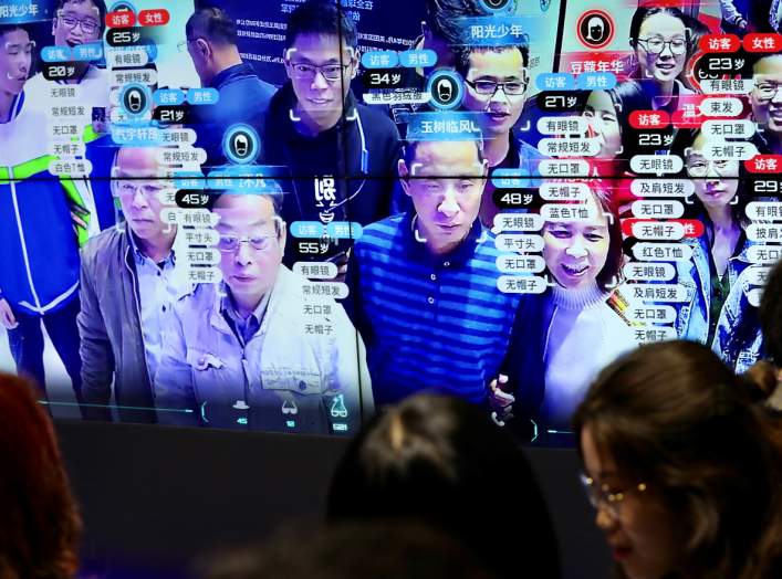 Visitors are seen at a screen displaying facial recognition technology at the Digital China Exhibition in Fuzhou, Fujian province, China May 8, 2019. China Daily via REUTERS