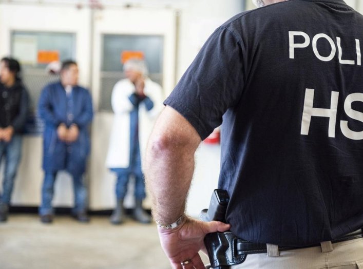 Image: Homeland Security Investigations (HSI) officers from Immigration and Customs Enforcement (ICE) look on after executing search warrants and making some arrests at an agricultural processing facility in Canton, Mississippi, U.S. in this August 7, 201